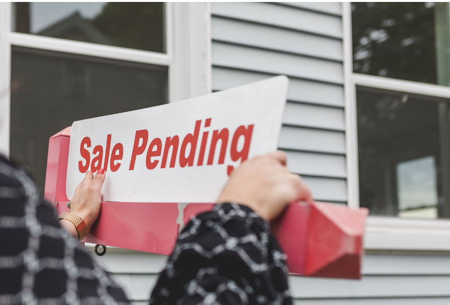 Realtor Putting up a ‘Sale Pending’ Sign